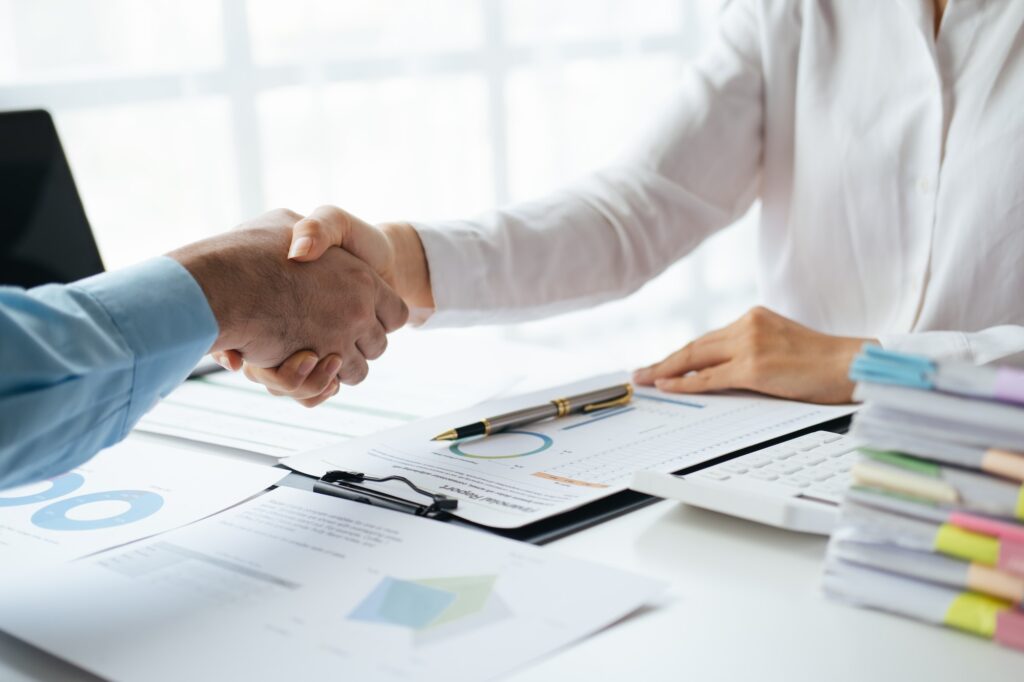 Close up view of business people making a handshake as successful negotiation ending.